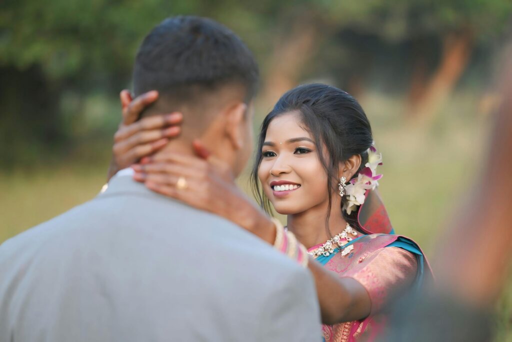 A romantic couple sharing a joyful moment in traditional Indian attire outdoors in Kumhariya, Jharkhand.