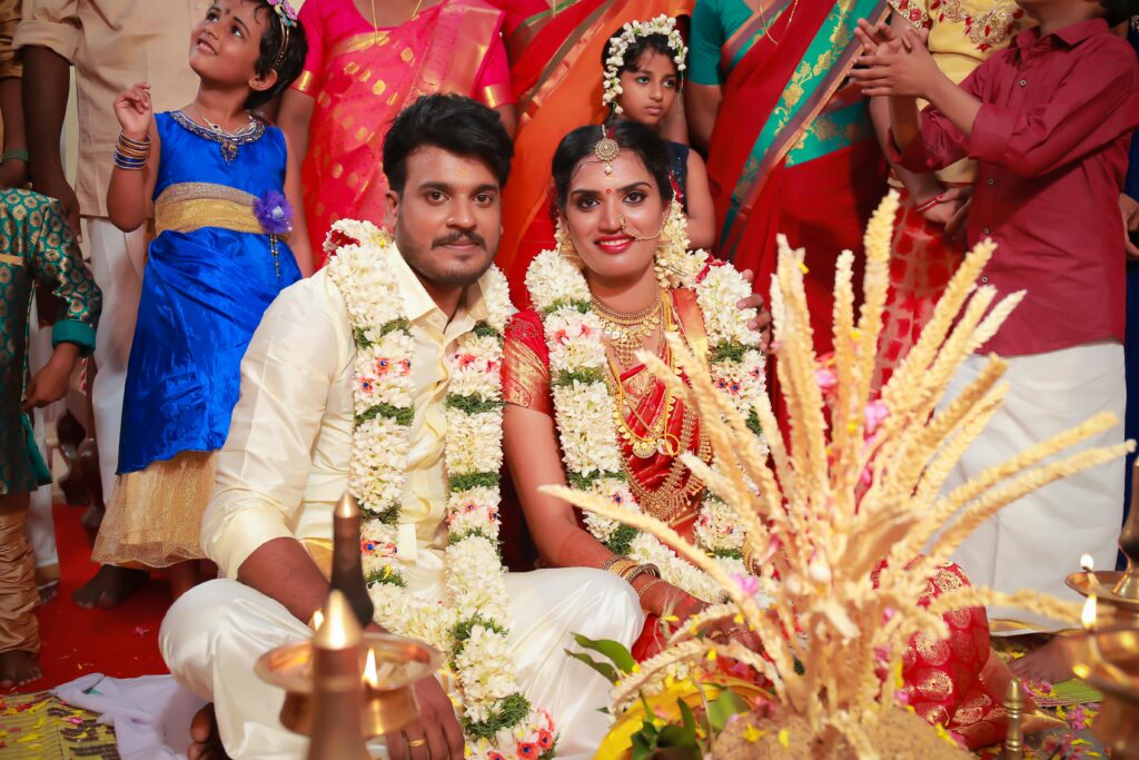 A vibrant Indian wedding ceremony with bride and groom adorned in floral garlands in Kerala.